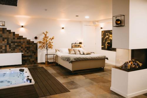 1 dormitorio con cama y bañera en Maas en Waal Wellness & Suites, en Dreumel