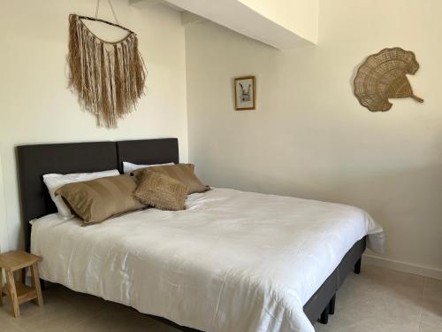 a bedroom with a large bed with white sheets at La Cigalière à 5 minutes de la plage à pied in Le Lavandou