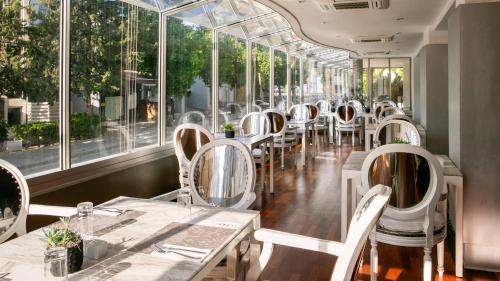 una fila di tavoli e sedie in un ristorante con finestre di Cleopatra Hotel a Nicosia