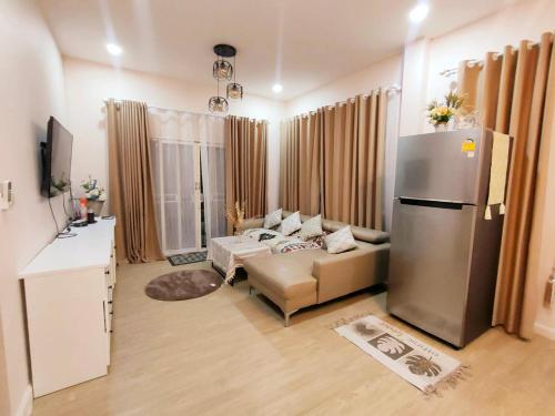 a living room with a couch and a refrigerator at คานาโฮมฮัก หนองกุง in Ban Tao No