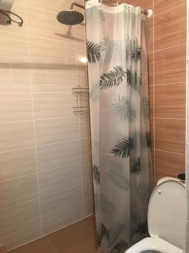 a bathroom with a shower curtain with a toilet at Гостевой дом in Karakol