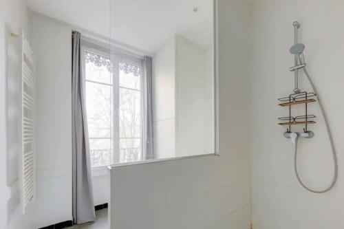 uma casa de banho branca com uma janela e um lavatório em Bel appartement Haussmannien au coeur du 7ème em Lyon