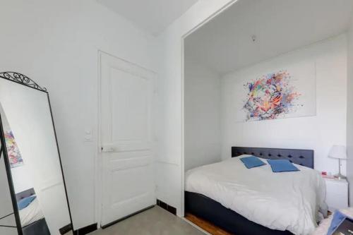 um quarto branco com uma cama e um espelho em Bel appartement Haussmannien au coeur du 7ème em Lyon