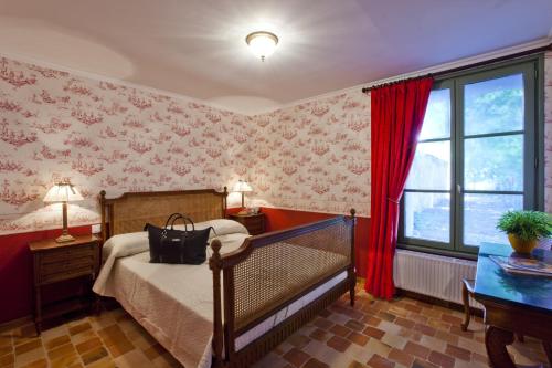 a bedroom with a bed and a red wall at Le Gîte du Château de la Vérie in Challans