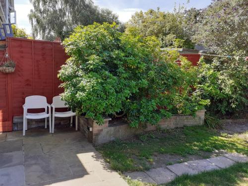a garden with two chairs and a bush at Home from home, single room with virgin channels, Wifi & free parking in Poole