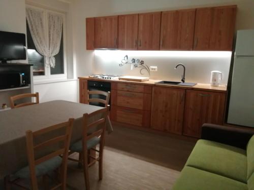 une cuisine avec des placards en bois et une table avec une salle à manger dans l'établissement Apartma AJJA, à Deskle