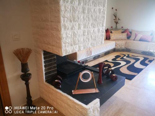 ein Wohnzimmer mit einem gemauerten Kamin und einem Besen in der Unterkunft Luxus Home in Oujda