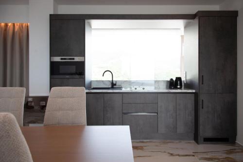 a kitchen with a table and a sink and a window at Zavia Penthouse in Syvota