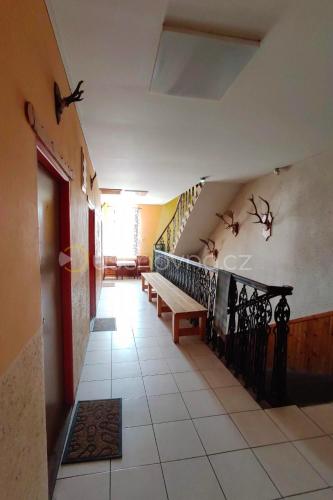 a hallway with a staircase with benches and birds on the wall at Penzion U Vorlu 