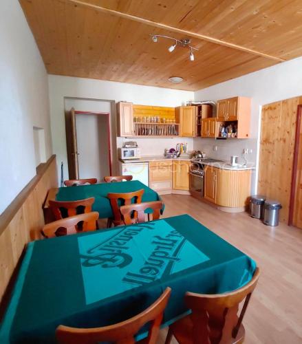 Habitación con mesa, sillas y cocina. en Penzion U Vorlu 