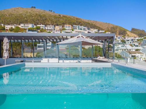 a large swimming pool with an umbrella and a mountain at The Murex in Cape Town