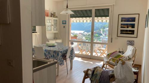 a kitchen with a table and a view of a balcony at Vista mare 6 minuti a piedi dalla spiaggia, box. in Moneglia