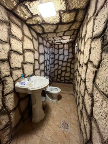 a stone bathroom with a sink and a toilet at Al-Nawatef ECO camp- Dana Nature Reserve in Dana