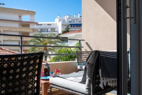 un balcon avec deux chaises et une table sur un balcon dans l'établissement PWS - Sunny modern flat near Juan Les Pins Pinede & beach - Terrace & AC!, à Antibes
