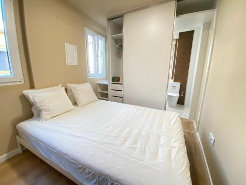 a bedroom with a large white bed and a mirror at Palmela Downtown Terrace in Palmela