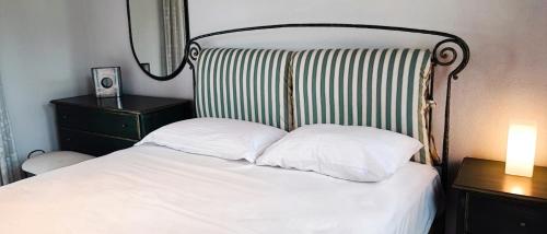 a bed with two white pillows and a mirror at Trikorfo Bungalows in Gerakini