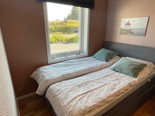 dwa łóżka w pokoju z oknem w obiekcie Holiday home Hellesøy w mieście Bøvågen