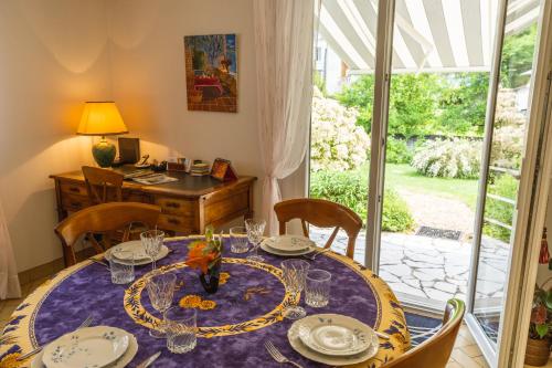 une salle à manger avec une table et des chaises et une fenêtre dans l'établissement Clos Fleuri : Amboise Home with Amazing Gardens, à Amboise