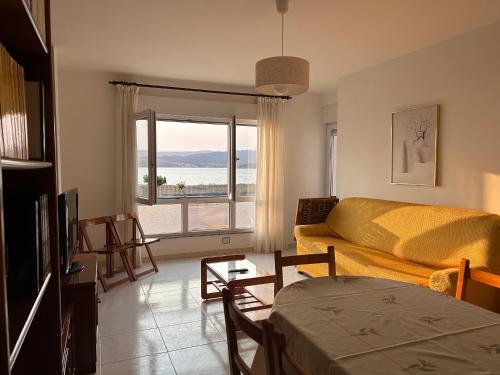 ein Wohnzimmer mit einem Sofa und Meerblick in der Unterkunft VUT Pedra de Mula in Portosín