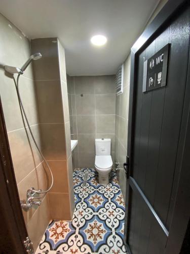 a bathroom with a toilet and a shower and a door at Ferah Hostel in Istanbul