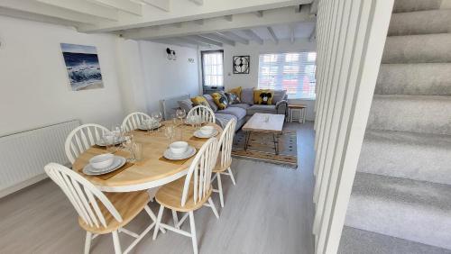 a dining room with a table and chairs and a couch at Bosun`s Cottage Luxury stay in the heart of town in Weymouth