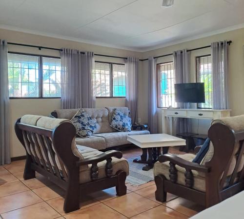 St Lucia的住宿－Stone House，客厅配有沙发和桌子