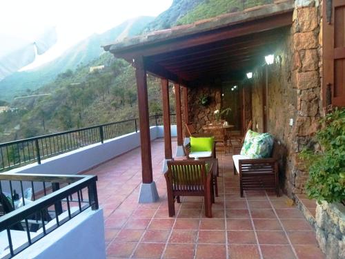 a patio with chairs and tables on a balcony at Live masca casatarucho in Buenavista del Norte