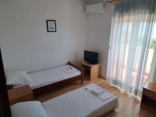 Habitación de hotel con 2 camas y TV en Apartments Filip, en Omiš