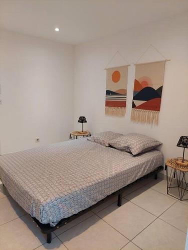 - une chambre avec un lit et deux tables de chevet dans l'établissement F3 2sdb proche centre et route des plages, à Montpellier