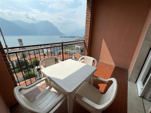 una mesa blanca y sillas en un balcón con vistas en Fabula Home Rental - Casa Pluto en Lovere