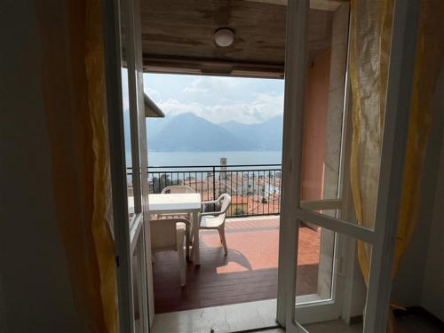 balcón con mesa y vistas al océano en Fabula Home Rental - Casa Pluto en Lovere