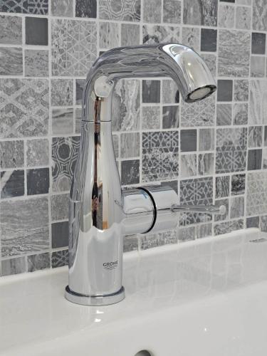 a kitchen sink with a mixer on a counter at Bosun`s Cottage Luxury stay in the heart of town in Weymouth