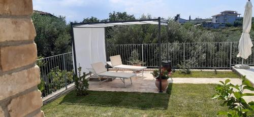 a patio with a white pergola and two chairs at Villa Fiorentina e la Costa dei Trabocchi in Marina San Vito