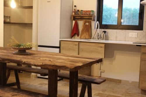 een keuken met een houten tafel en een koelkast bij La bergerie des petits loups in Montagnac-la-Crempse