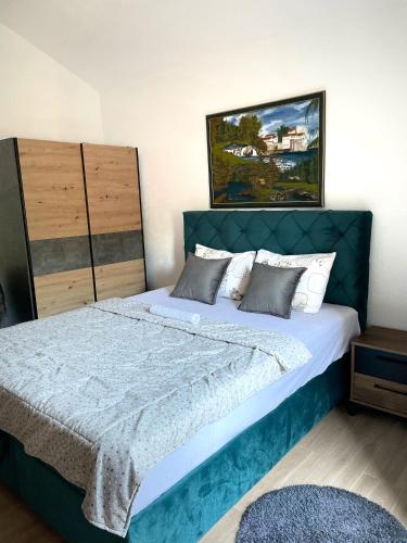 a bedroom with a large bed with a blue headboard at Studios Merdović in Budva