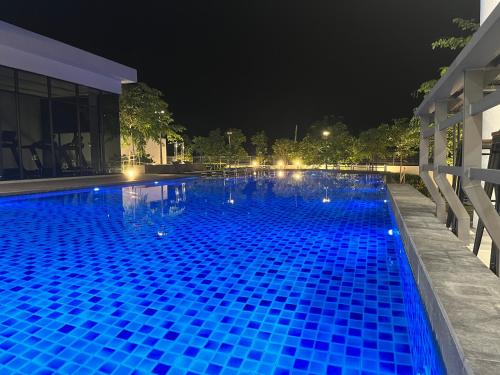 a large blue swimming pool at night at MVISTA 3BR AirportView CozyStay in Bayan Lepas