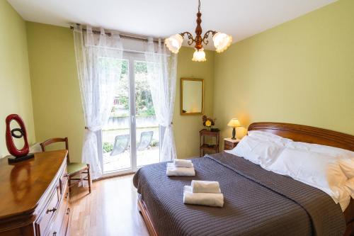ein Schlafzimmer mit einem Bett mit zwei Handtüchern darauf in der Unterkunft Clos Fleuri : Amboise Home with Amazing Gardens in Amboise