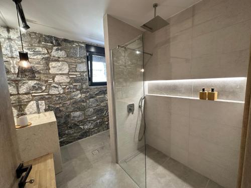 a bathroom with a shower with a glass door at Windmills & The Villas-Aiolos l in Áno Váthia