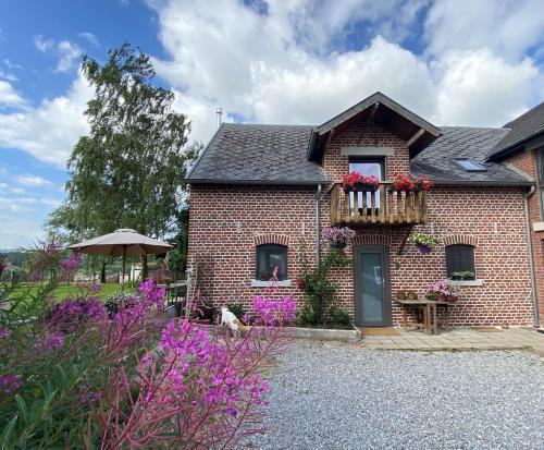 une maison en briques avec un balcon fleuri dans l'établissement Ô Macra House - Aubel, Pays de Herve, à Aubel