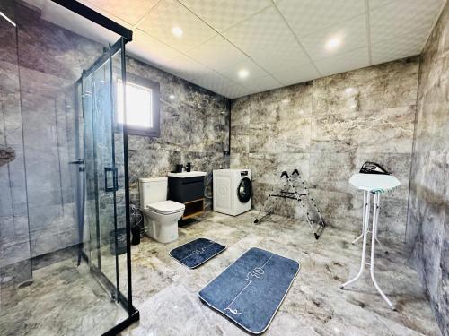 a bathroom with a shower and a toilet at KUŞADASI DAVUTLARDA 4+1 ÖZEL BAHÇELİ KİRALIK LÜKS VİLLA in Kuşadası