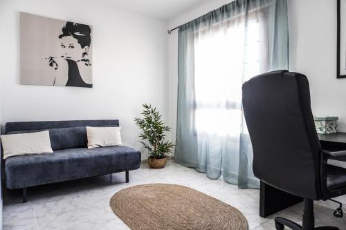 salon z niebieską kanapą i krzesłem w obiekcie Bright House With Working Space w mieście El Médano