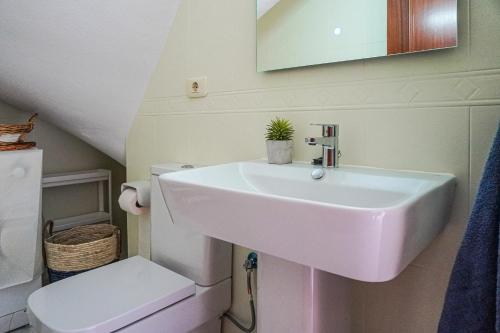 a bathroom with a sink and a toilet at Bright House, Pool & Workspace near Medano Beach in El Médano