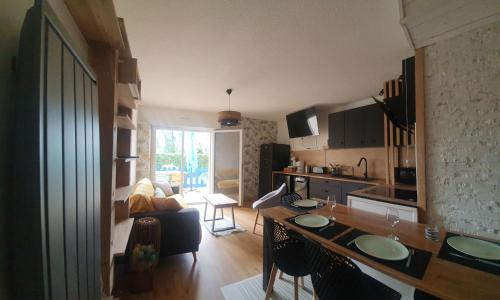uma cozinha e sala de estar com uma mesa num quarto em Appartement rez de jardin proche du centre ville de sarzeau em Sarzeau