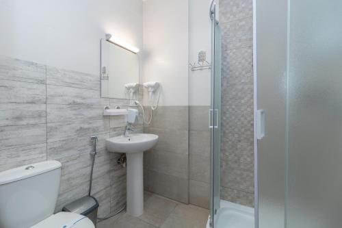 a bathroom with a toilet and a sink and a shower at Opera Passage Hotel & Apartments in Lviv