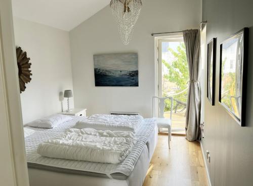 a white bedroom with a bed and a window at Unique holiday accommodation on Langholmen in Gothenburgs western archipelago in Torslanda