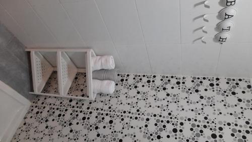 y baño con ducha y azulejos blancos y negros. en Tamesna HOUSE, en Sidi Yahia az Zaʼer