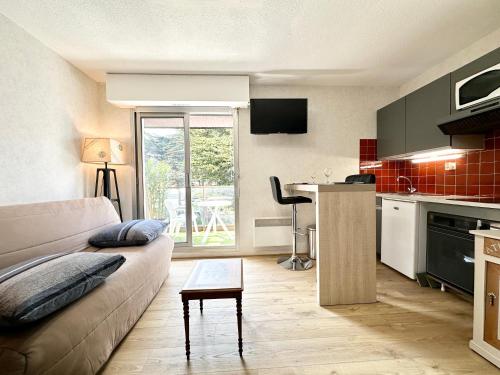 sala de estar con sofá y cocina en Studio archi cosy – Refait à neuf – 5min des plages, en Quiberon