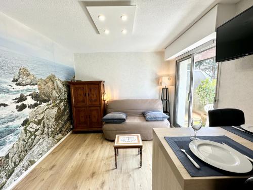 Habitación con cama y mesa con lavamanos en Studio archi cosy – Refait à neuf – 5min des plages, en Quiberon