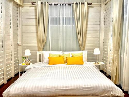 - une chambre avec un lit et 2 oreillers jaunes dans l'établissement บ้านแสนรัก Casa Dolce Casa, Prakhon Chai, à Prakhon Chai
