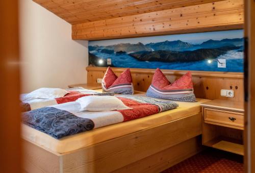 a bedroom with two beds with red and white pillows at Walchensee - Alpenblick Tilly in Krün